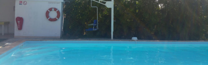 Swimming pool with special seat for disabled persons